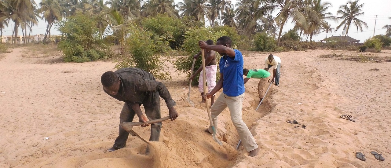 Hommes creusant tranché pour accès à l'eau